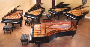 Overhead view of 5 concert grand pianos in recital hall